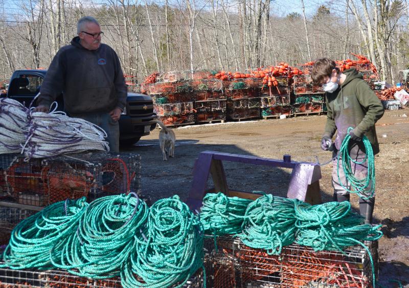 Rockport fisherman Kenneth Dodge and one of his sternmen, Damian Weaver, with all the lines to which purple paint needs to be applied. (Photo by Lynda Clancy)