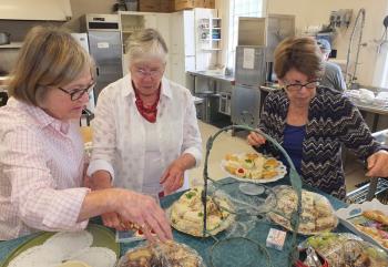 Sarah Wilds, Kris Mikkelsen and Adrian Mavragis prepare snacks for the lecture.