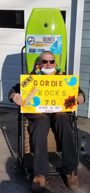 Gordie Guist, of Camden, watches a caravan of 30 cars passing by his home, many with canine passengers, who surprised him with a drive-by celebration on his 70th birthday April 19. (Photo courtesy of Robin Guist)