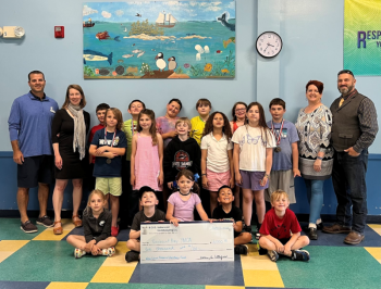 Students from the Y’s After School Program at South School join Director of Sports, Camping, and After School Care Benjie Blake and CEO Whitney Files for a check presentation from Karen Littlefield of B.O.G. balance bookkeeping, LLC, and her husband Errol Littlefield, an Ed Tech 3 at South School. (Photo courtesy Penobscot Bay YMCA)