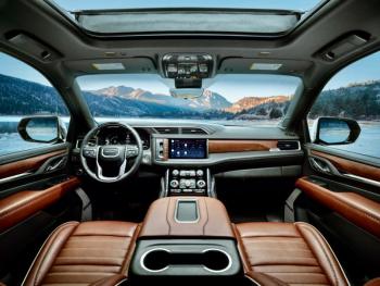 No, that’s not Mt. Denali in the distance, nor the Yukon Territory. Instead, focus more closely and note the Yukon Denali Ultimate’s luxurious and even tasteful Alpine Umber leather-swaddled cabin with many actual switches and buttons plus massaging seats, a 12-inch screen, inductive phone charger, ample storage space and power outlets, and (in the steering-wheel rim) the eyeball scanner that enables Super Cruise hands-free driving.
