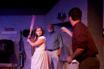 Pegeen (Greta Brown, left) faces off with Christy (Tyler Johnstone, front) as Michael (Greg Marsanskis, back) looks on. (Photo courtesy Belfast Maskers)