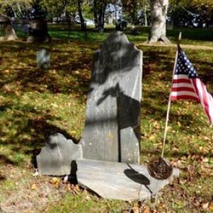 Kate Marshall, (not shown) of Nevada, came to Tolman Cemetery to view her Patriot ancestor’s grave. She found the gravestone of Benjamin Blackington (1749-1812) in several pieces, broken away from the double headstone with his wife, Eunice Woodcock (1743-1815). The image by Carl Mahoney shows the stone awaiting restoration and reuniting.