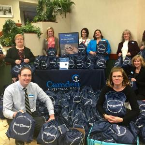 The Midcoast team with the completed kits (l-r), back row: Randy Cruz, Vickie Hersom, Jody Landrith, Nicole Hotchkin, Carissa Christie, Ann Brindle, Samantha Helander; front row, kneeling, (l-r), Jim Jarvis, Juanita Paparello and Crystal Spear.