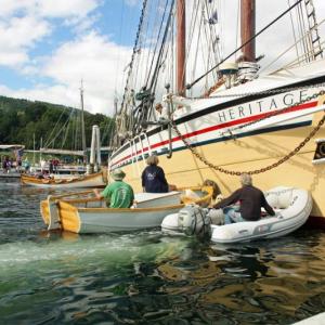 A few perfectly placed pushes are needed Friday afternoon to maneuver the schooner Heritage back into a berth on the town docks at the head of Camden Harbor at the start of the 2016 Camden Windjammer Festival. (Photo by Holly S. Edwards)