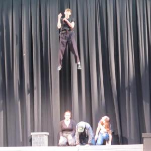 Wesley Henderson, one of the students playing Bert in Mary Poppins, is lifted on the Track on Track flying system while the cast looks on. (Photo by Kay Stephens)