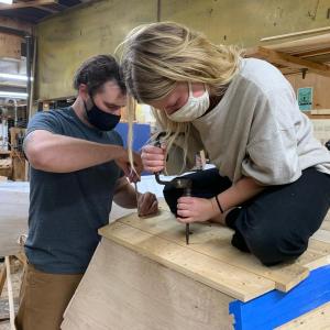 Amber and Max fasten in the last bottom plank on their Susan Skiff. (Photo courtesy The Apprenticeshop)