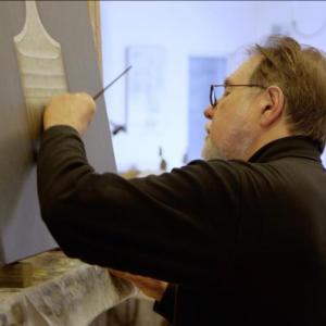 Film still of Alan Magee painting in his studio. (Photo courtesy Cushing Public Library)