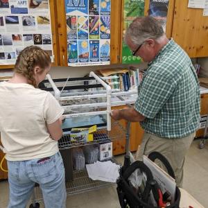 Belfast Marine Institute's student Laney Scheafe and teacher Chip Lagerbom assemble the lighting system for a kelp nursery aquarium. (Photo by David Thomas)