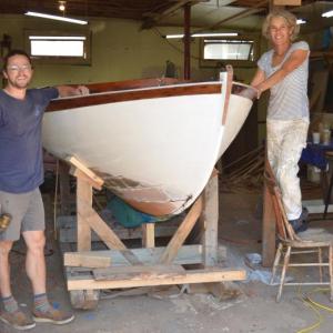 Cody Smith and Lisa Morgan, with ‘Wren’, finishing her restoration before a Sept. 15 launch. (Photo by Lynda Clancy)