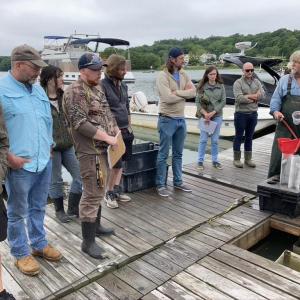 Aquaculture in Shared Waters cohort gets a tour of the Pemaquid oyster floating upweller system from oyster farmer Smokey McKeen. Chris Davis photo