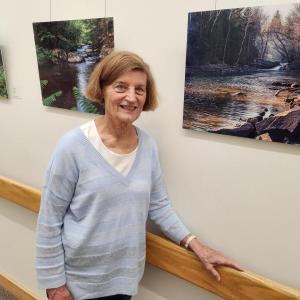 Photographer Judy O’Dell stands with her work on display at Pen Bay Medical Center near the main entrance.
