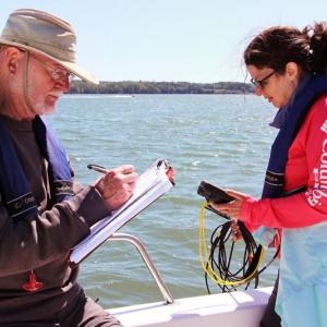 Coastal Rivers Conservation Trust volunteers use a sonde device to collect water quality data in the Damariscotta River estuary. (Photo courtesy Kris Christine)