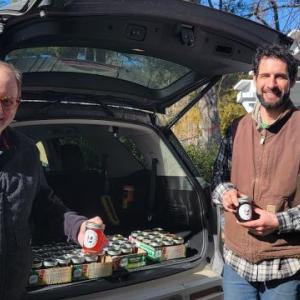Aaron Englander helps volunteer Michael Leonard load his vehicle with jars of maple syrup to donate to Come Spring Food Pantry. (Photo courtesy MCHT)