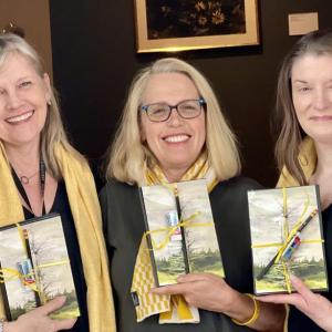 From left to right, each holding one of the 100 Andrew Wyeth journals donated by the Farnsworth Museum to domestic abuse survivors: Katherine Karlik, the museum’s Manager of Community Engagement and Volunteers; Finding Our Voices CEO and founder Patrisha McLean; and Gwendolyn Loomis Smith, the museum’s Phyllis Wyeth Director of Learning and Engagement. (Photo supplied by Finding Our Voices)