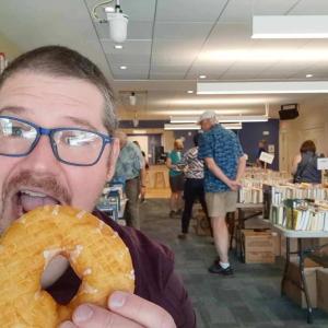 Rockport Library Director Ben Blackmon enjoys sweet treats and sweet deals at the 2023 Donut Festival Book Sale. (Photo courtesy Rockport Public Library)