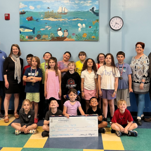 Students from the Y’s After School Program at South School join Director of Sports, Camping, and After School Care Benjie Blake and CEO Whitney Files for a check presentation from Karen Littlefield of B.O.G. balance bookkeeping, LLC, and her husband Errol Littlefield, an Ed Tech 3 at South School. (Photo courtesy Penobscot Bay YMCA)