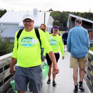 Volunteers haul kayaks to the water as they prepare to support the swim portion of the Pemaquid Beach Triathlon in 2023. (Photo courtesy Bristol Parks and Recreation)