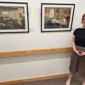 Hillary Mishcon, PharmD, a Pen Bay pharmacist and one of the exhibit’s featured artists, stands with her work. (Photo courtesy Pen Bay Medical Center)